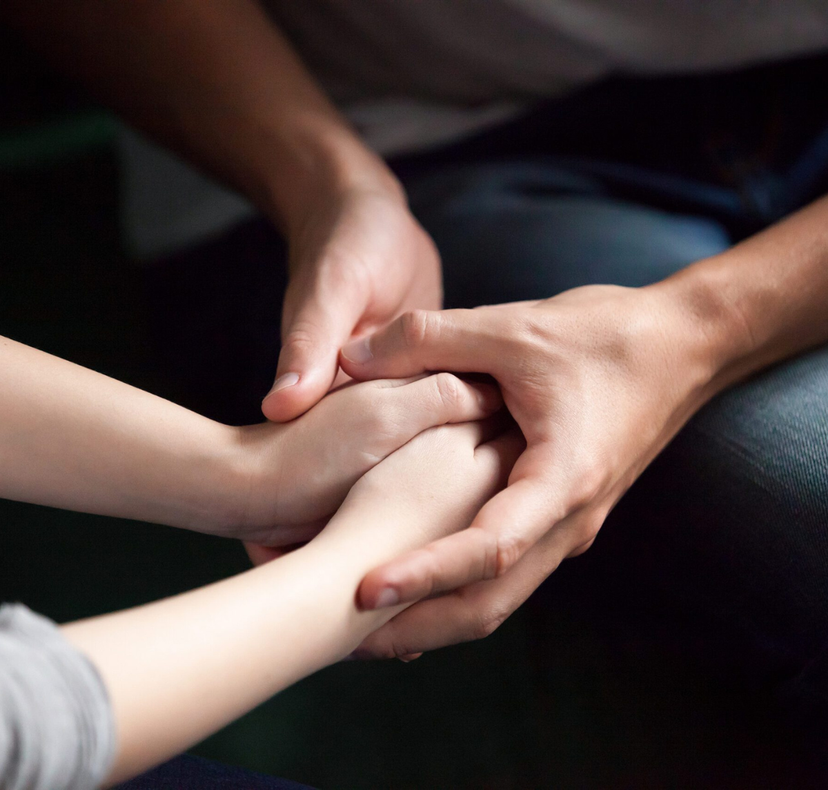 two individuals holding hands
